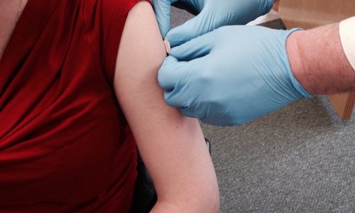 A photo of a young woman receiving a flu vaccine